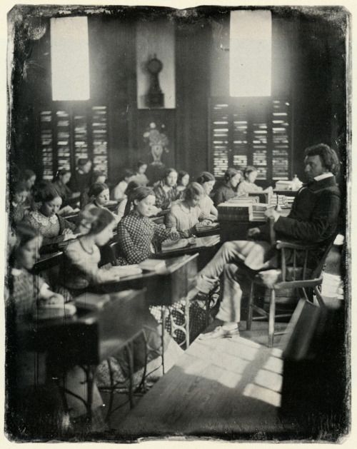 Foto antigua de un maestro impartiendo clase.