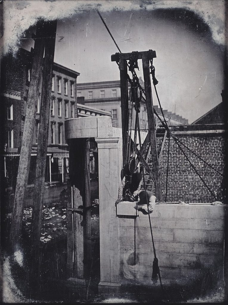 Foto antigua de obreros trabajando en la construcción de un edificio.