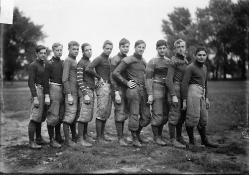 Football team, North Division High School, ten players standing in a line on an athletic field, 1905. Photograph by the Chicago Daily News.